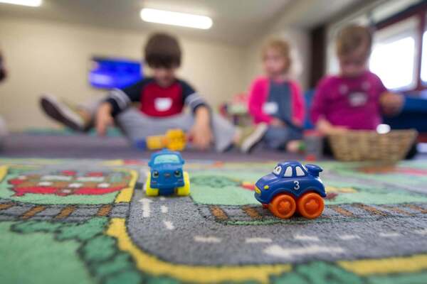 enfants qui jouent aux voitures dans une crèche collective