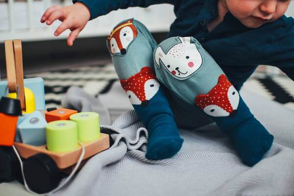 Texte alt : jeune enfant gardé en maison d’assistantes maternelles qui joue avec des cubes